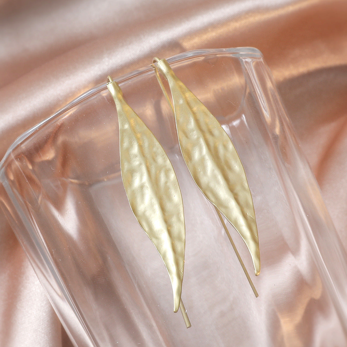 gold leaf earrings on glass